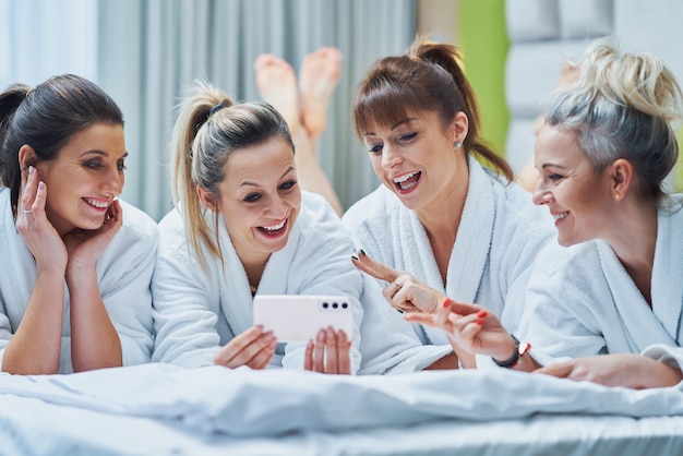 Chicas en fiesta de spa en hotel con teléfono