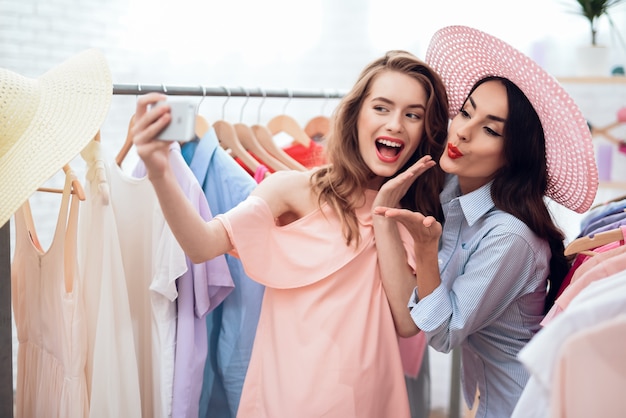 Las chicas gloriosas miran la ropa en la sala de exposición.