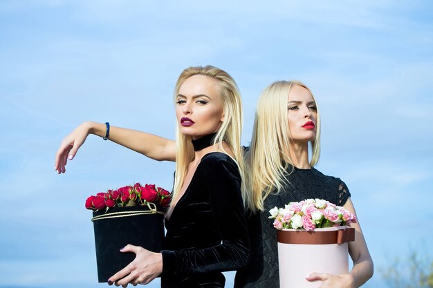 Chicas guapas con flores en caja