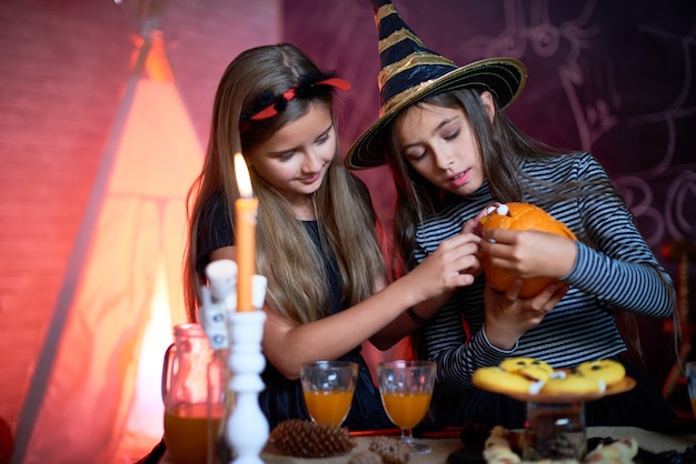 Chicas guapas haciendo calabaza tallada