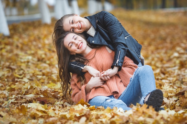 Chicas guapas jóvenes posando al aire libre en otoño