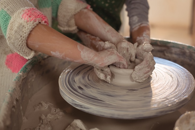 Chicas haciendo maceta en taller de cerámica