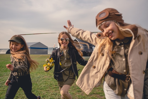 Chicas interpoladas alegres que se ejecutan en el campo de vuelo del aeroclub