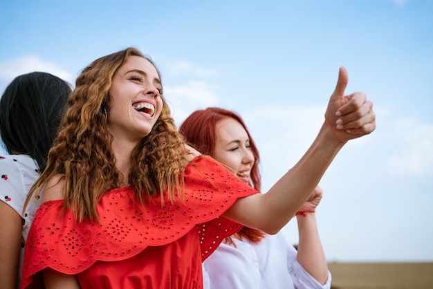 Chicas jóvenes alegres bailando en el fondo del cielo en verano