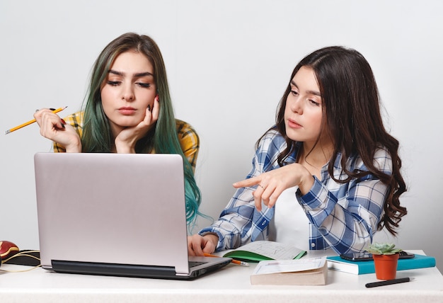 Chicas jóvenes estudiantes con laptop estudiando juntos