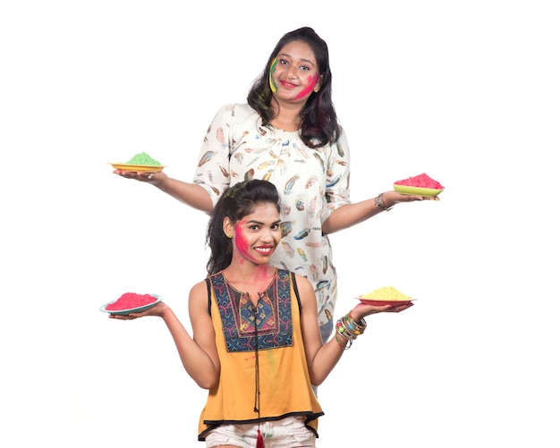 Chicas jóvenes felices divirtiéndose con polvo de colores en el festival de colores de Holi