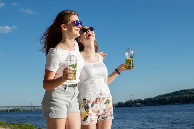 Chicas jóvenes y felices pasean por la playa