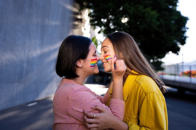 chicas lesbianas que se divierten pintándose y con la bandera lgtb en el día del orgullo concepto lgtb