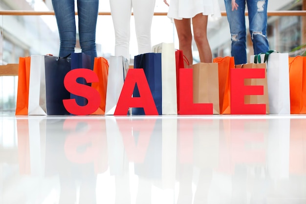 Foto chicas con letras rojas de venta en concepto de compras en centros comerciales