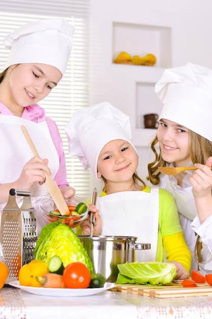 Foto chicas lindas felices cocinando plato de verduras