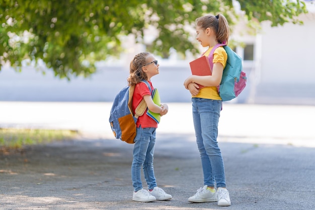 Chicas con mochila van a la escuela.