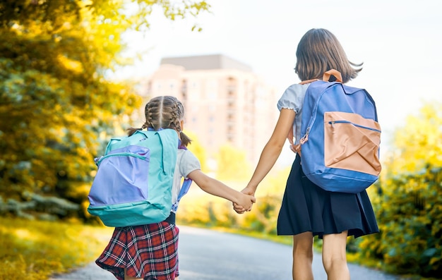 Chicas con mochila van a la escuela.