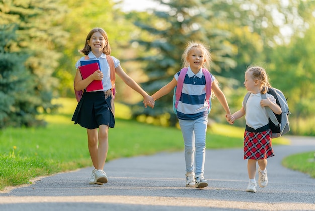 Chicas con mochila van a la escuela.