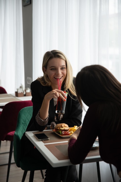 chicas sentadas y hablando en una cafetería