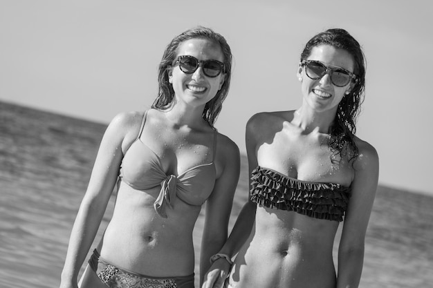 Chicas sonrientes en bikini mirando a la cámara en la playa en la isla de Koh Phangan Tailandia