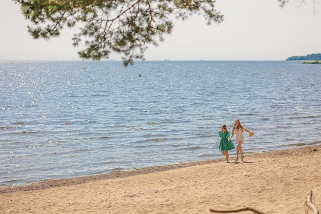 Chicas sonrientes caminando por la costa Concepto de amistad, entretenimiento y diversión