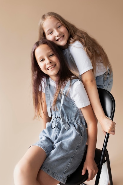 Chicas de tiro medio posando con silla