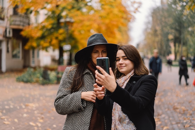 Chicas usando teléfono en el parque