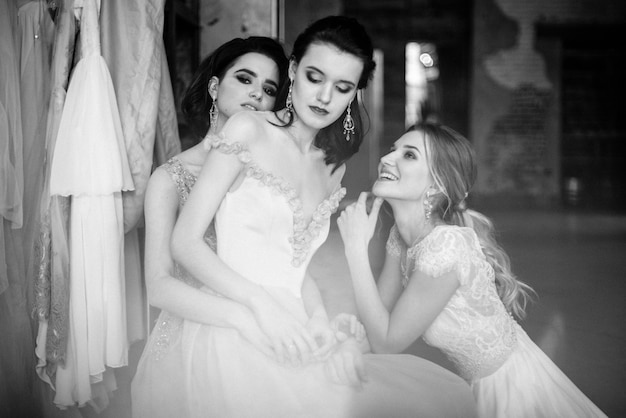 Chicas en vestidos de novia blancos están posando.