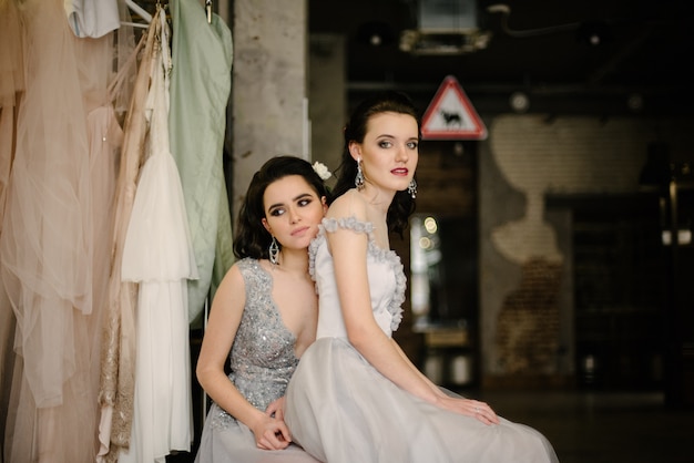 Las chicas con vestidos de novia blancos están posando