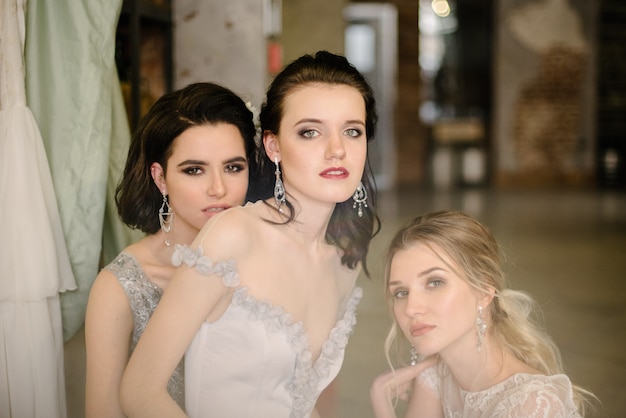 Las chicas con vestidos de novia blancos están posando