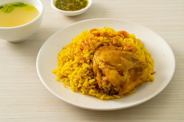 Chicken Biryani oder Curryreis und Hühnchen - thailändisch-muslimische Version des indischen Biryani, mit duftendem gelbem Reis und Hühnchen - muslimische Küche