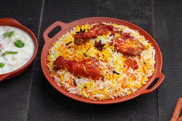 Chicken Mandi Biryani arrangiert in einem Steingut mit schwarzem Hintergrund oder Textur