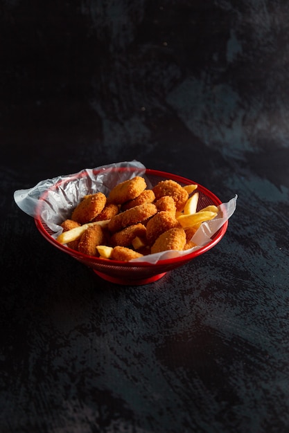 Chicken Nuggets im roten Topf mit Pommes frites