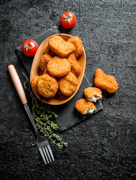 Foto chicken nuggets in einer schüssel mit gabelthymian und tomaten