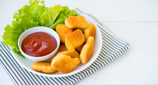 Chicken Nuggets mit Sauce und Kräutern in einem Teller, selektiver Fokus, Kopierraum