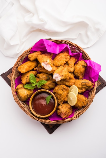 Chicken Pakora o pakoda o buñuelos es un bocadillo indio popular en el que se marinan trozos de pollo deshuesados y luego se recubren con una mezcla de besan, harina de arroz, harina de maíz y huevo.