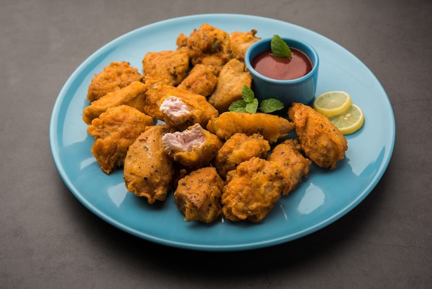 Chicken Pakora oder Pakoda oder Fritters ist ein beliebter indischer Snack, bei dem Hähnchenstücke ohne Knochen mariniert und dann mit einer Mischung aus Besan, Reismehl, Maisstärke und Ei überzogen werden
