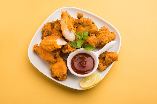 Chicken Pakora oder Pakoda oder Fritters ist ein beliebter indischer Snack, bei dem Hähnchenstücke ohne Knochen mariniert und dann mit einer Mischung aus Besan, Reismehl, Maisstärke und Ei überzogen werden