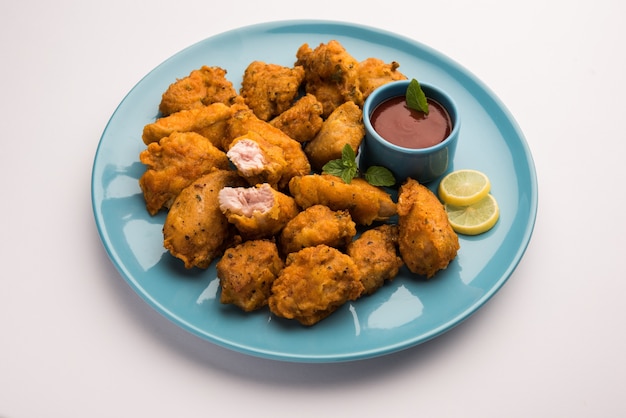 Chicken Pakora oder Pakoda oder Fritters ist ein beliebter indischer Snack, bei dem Hähnchenstücke ohne Knochen mariniert und dann mit einer Mischung aus Besan, Reismehl, Maisstärke und Ei überzogen werden