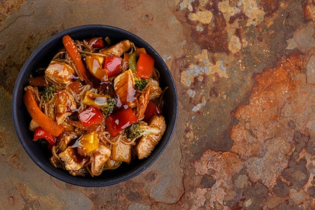 Chicken Yakissoba in schwarzer Keramikschale - Ansicht von oben.