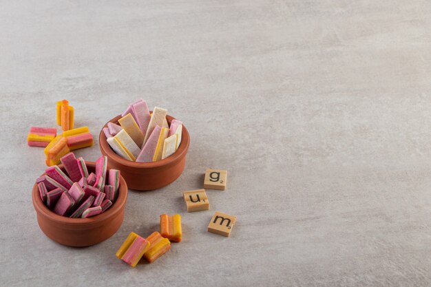 Chicles de colores colocados sobre una mesa de piedra.