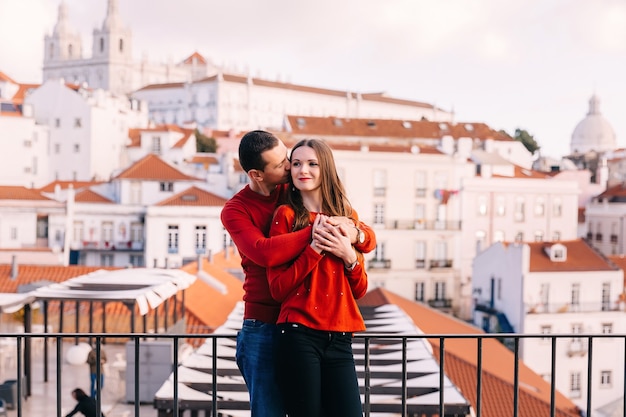 El chico abraza y besa a la chica en el fondo de la ciudad. en el fondo de la ciudad.