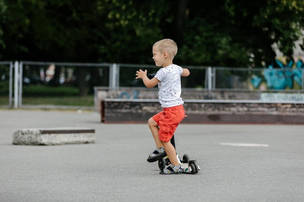 Foto chico activo montando una moto en el parque de patinaje de verano