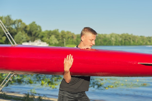 Chico adolescente con kayak de barco deportivo, deportes acuáticos