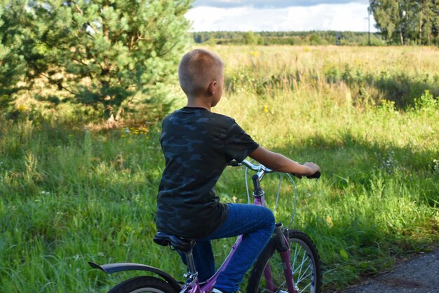 Chico adolescente monta una bicicleta en el bosque