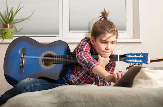 Chico adolescente tocando la guitarra en casa