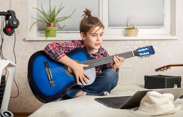 Chico adolescente tocando la guitarra en casa