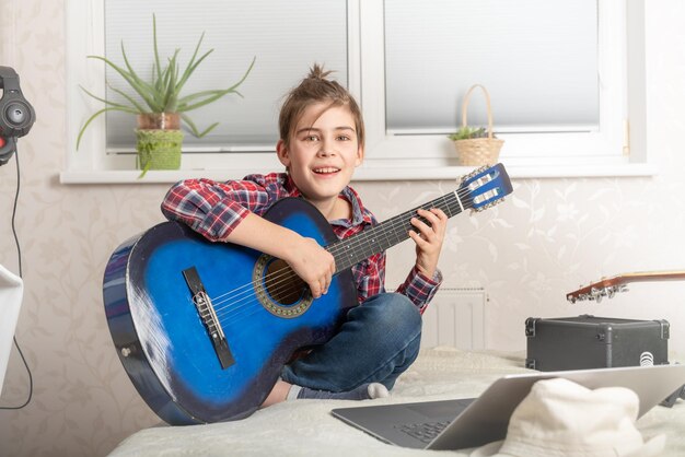 Foto chico adolescente tocando la guitarra en casa