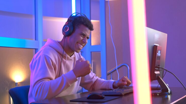 Chico africano alegre que gana el tirador en línea en el campeonato de juegos en línea en Internet. Está muy feliz y emocionado.