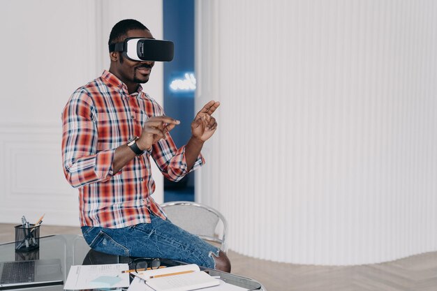 Chico afroamericano en gafas VR interactúa con realidad virtual aumentada para compras de comercio electrónico