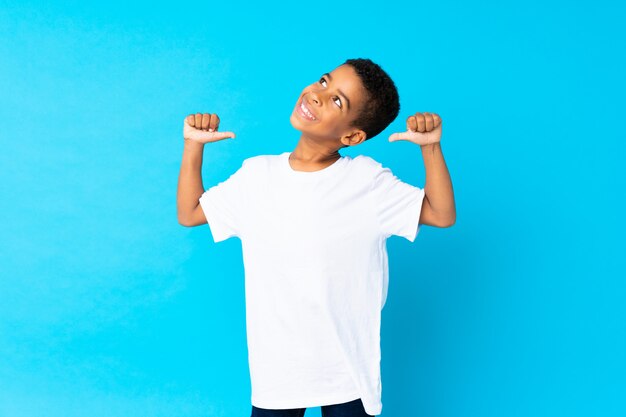 Foto chico afroamericano sobre azul aislado orgulloso y satisfecho de sí mismo