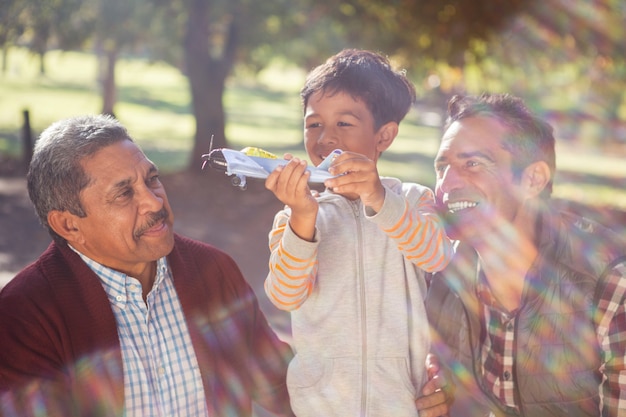 Chico alegre con avión de juguete por familia