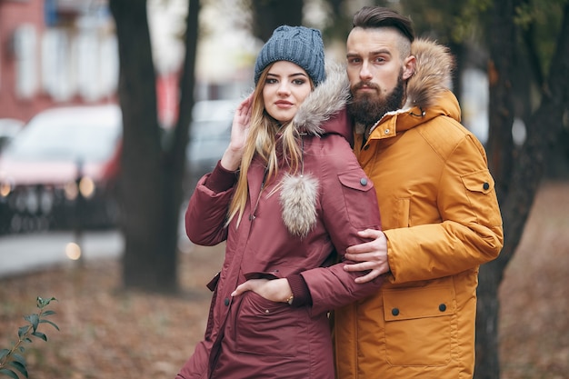 Un chico alegre y una chica están caminando en el parque de otoño.