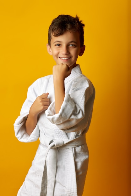 Chico alegre en kimono blanco sonriendo