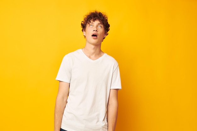 Chico alegre con el pelo rizado en un estilo juvenil camiseta blanca